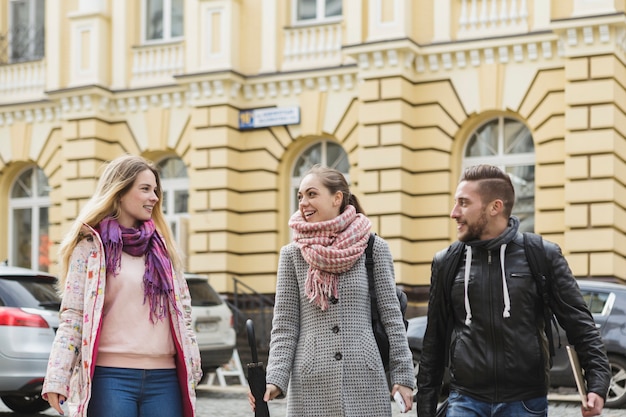 Uomo allegro e donne che camminano sulla strada