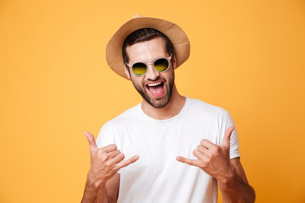 Uomo allegro in cappello di estate che guarda l'obbiettivo