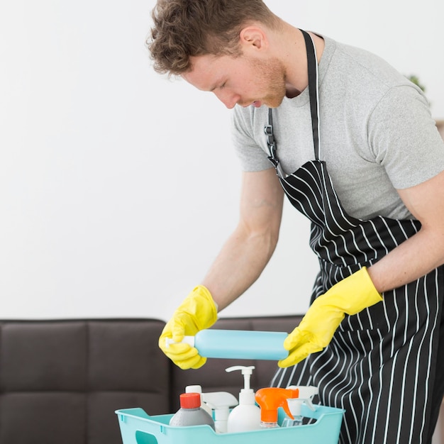 Uomo alto angolo con cesto di detergenti