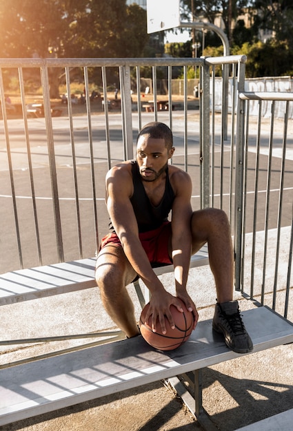 Uomo alto che si prende una pausa dal basket