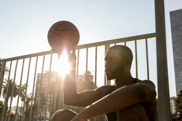 Uomo alto che si prende una pausa dal basket