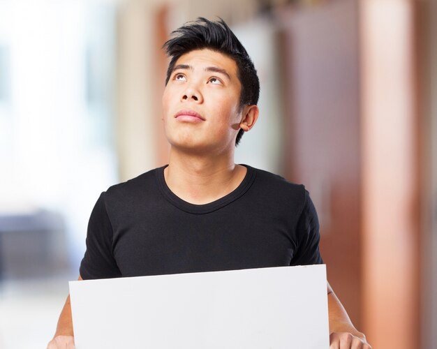 Uomo alzando lo sguardo mentre si tiene un cartello bianco