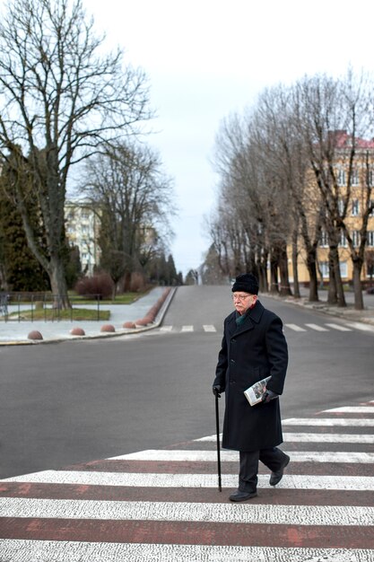 Uomo anziano a figura intera che fa una passeggiata