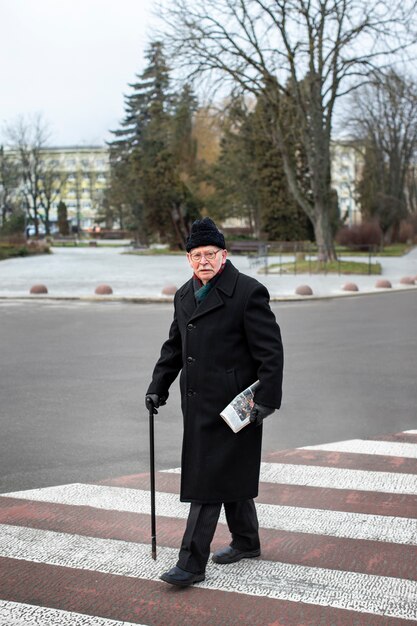 Uomo anziano a figura intera che fa una passeggiata