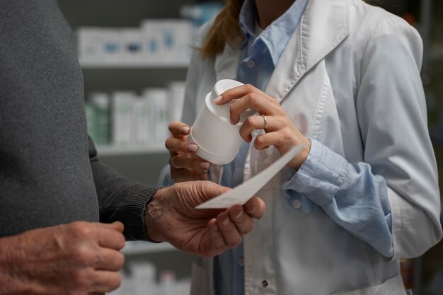 Uomo anziano che consulta farmacista femminile sul farmaco