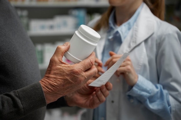 Uomo anziano che consulta farmacista femminile sul farmaco