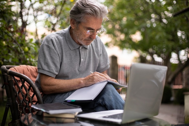 Uomo anziano che fa lezioni online su un laptop