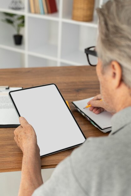 Uomo anziano che fa lezioni online su un tablet