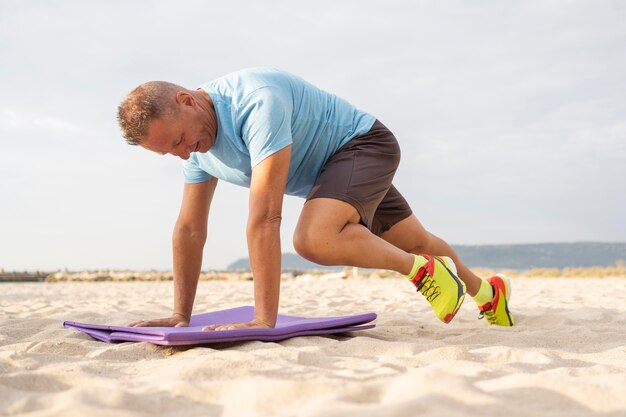 Uomo anziano che lavora sulla spiaggia