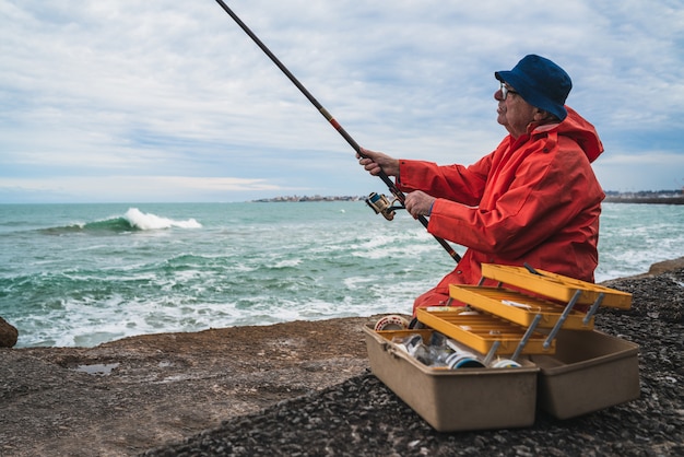 Uomo anziano che pesca nel mare.