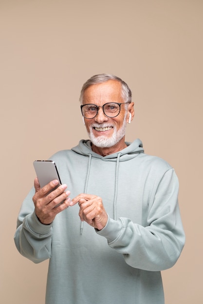 Uomo anziano con colpo medio che tiene smartphone