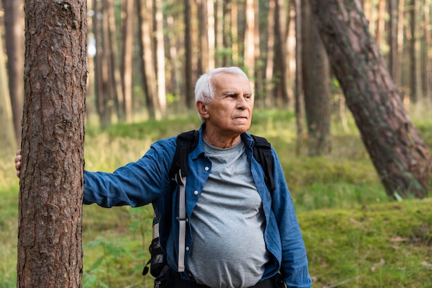 Uomo anziano con lo zaino in spalla nella natura