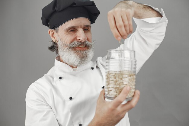 Uomo anziano con un barattolo di farina d'avena. Approccio professionale al business.