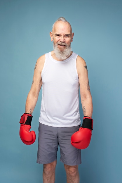 Uomo anziano di tiro medio con guanti da boxe