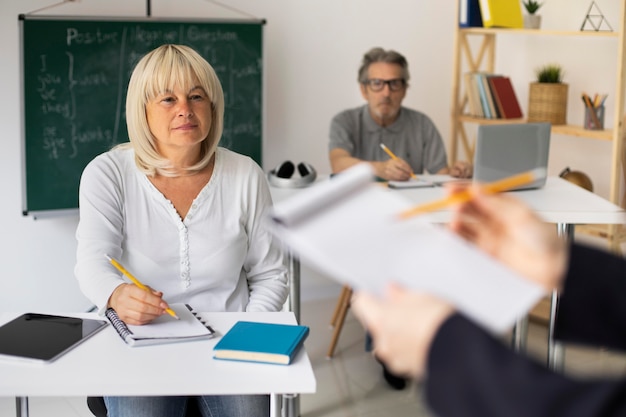 Uomo anziano e donna che prestano attenzione in classe