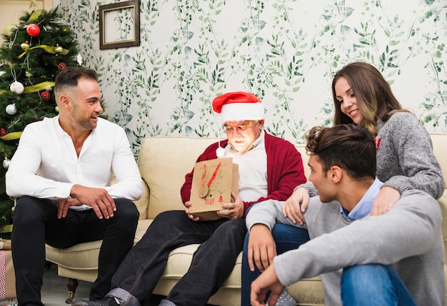 Uomo anziano guardando lucente borsa regalo