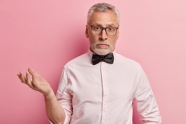 Uomo anziano in camicia rosa e papillon nero