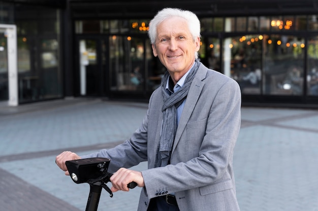 Uomo anziano in città con scooter elettrico