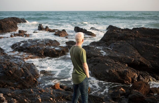 Uomo anziano in riva al mare, colpo medio