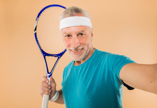 Uomo anziano moderno con la racchetta da tennis