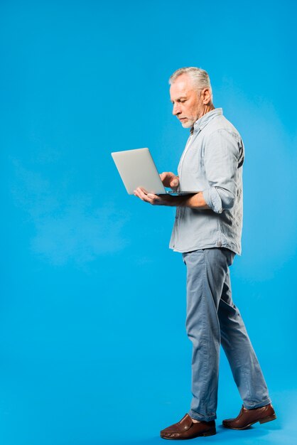 Uomo anziano moderno con laptop