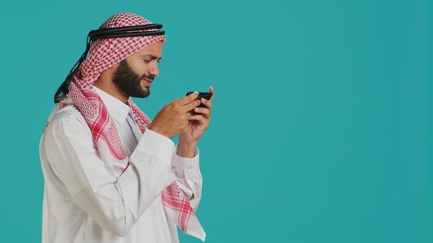 Uomo arabo che gioca a divertenti videogiochi mobili
