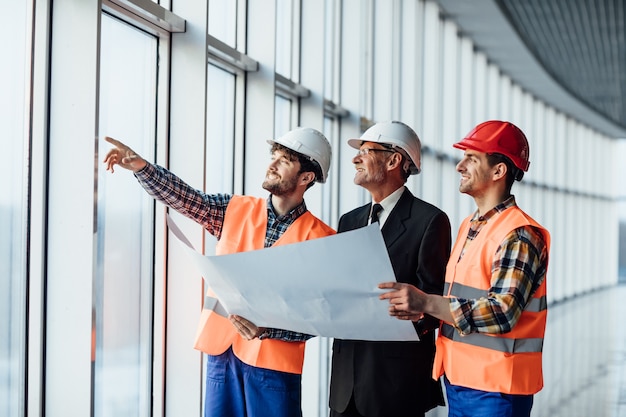 Uomo architetto che mostra qualcosa sul progetto al suo collega caposquadra