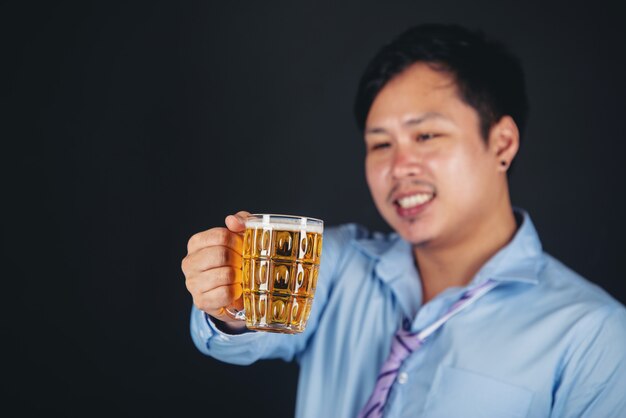 uomo asiatico che beve un boccale di birra