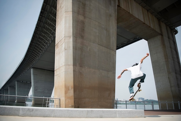 Uomo asiatico che fa skateboard in città all'aperto