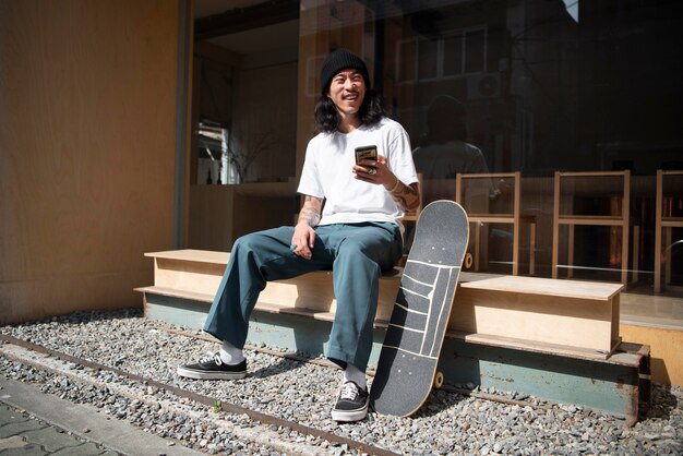 Uomo asiatico che si prende una pausa dallo skateboard