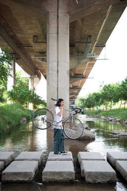 Uomo asiatico che tiene la sua bici