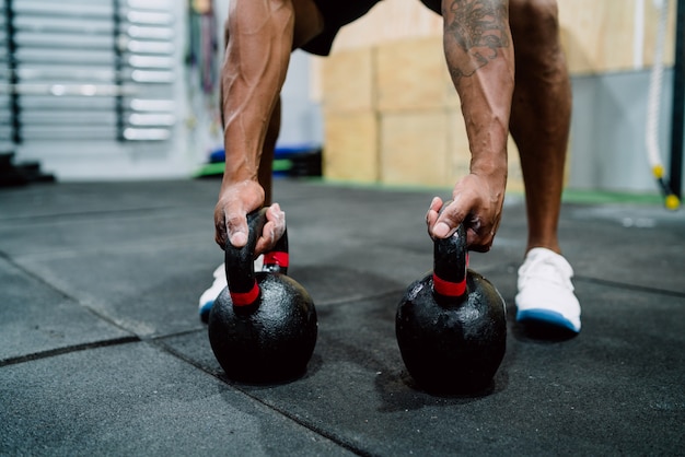 Uomo atletico che fa esercizio con kettlebel crossfit.