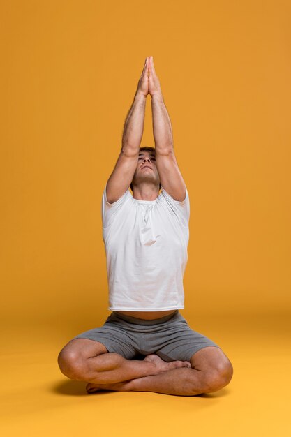 Uomo atletico che fa posa di yoga