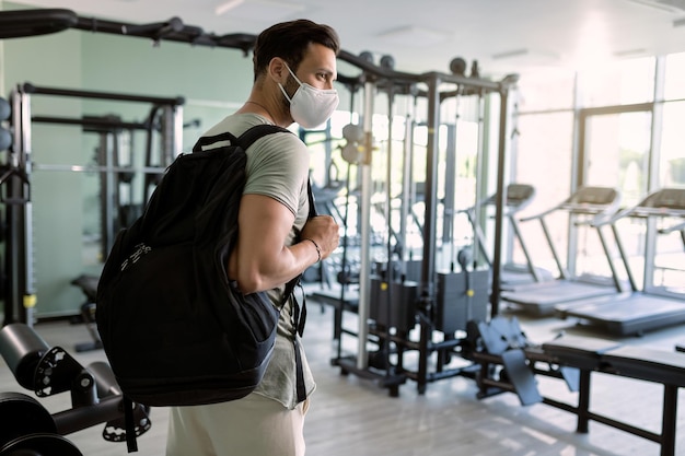 Uomo atletico con maschera protettiva che entra in palestra