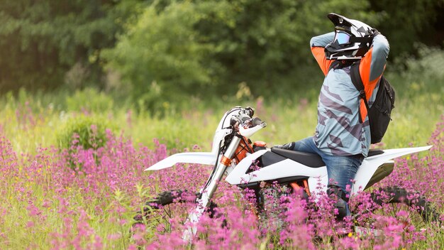 Uomo attivo felice di guidare una moto nella natura