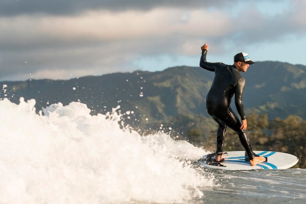 Uomo attivo in attrezzatura speciale che fa surf alle hawaii