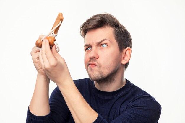 Uomo attraente di affari di 25 anni che sembra sconcertante il puzzle di legno.