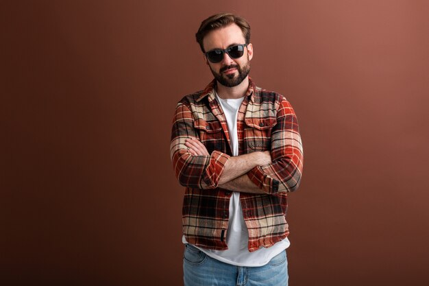 Uomo barbuto alla moda bello hipster brutale su colore marrone