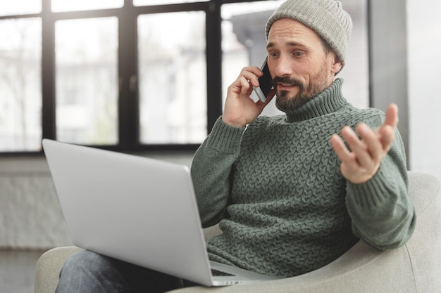 Uomo Barbuto che indossa cappello e maglione caldo lavorato a maglia