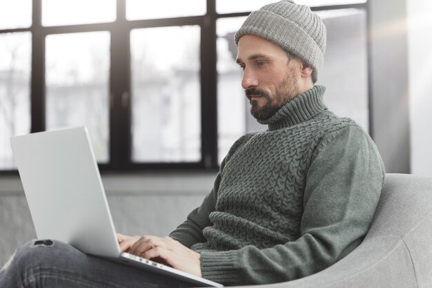 Uomo Barbuto che indossa cappello e maglione caldo lavorato a maglia