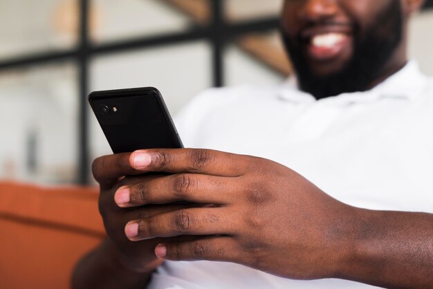 Uomo barbuto che passa in rassegna il suo telefono cellulare