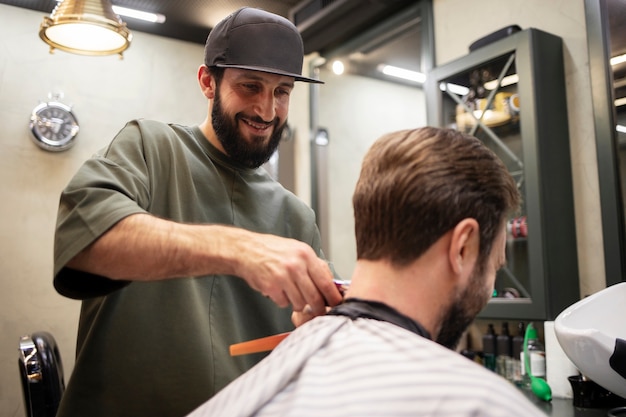 Uomo barbuto che si fa tagliare i capelli dal barbiere