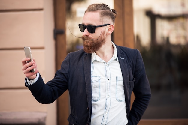 Uomo barbuto con il telefono