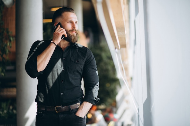 Uomo barbuto con il telefono