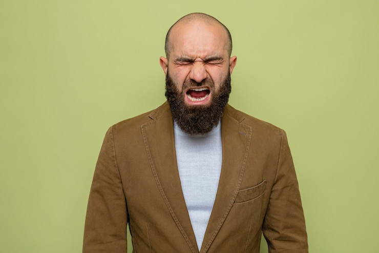 Foto gratuito uomo barbuto in abito marrone che grida e urla pazzo pazzo e frustrato