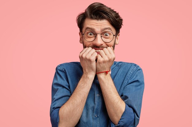 Uomo barbuto in camicia di jeans e papillon rosa