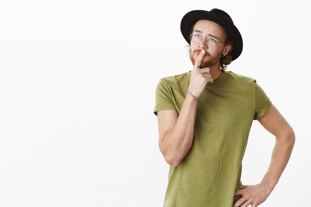 Uomo barbuto rosso espressivo con un cappello