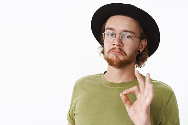 Uomo barbuto rosso espressivo con un cappello