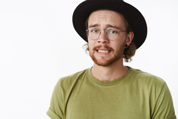 Uomo barbuto rosso espressivo con un cappello