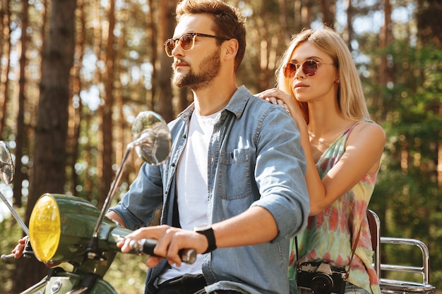 Uomo barbuto su scooter con la fidanzata all'aperto